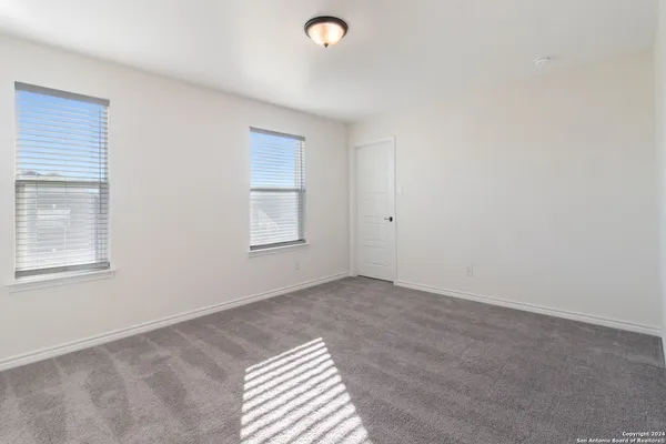 a view of an empty room with window and closet area