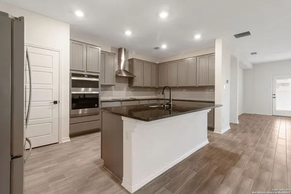 a kitchen with kitchen island a sink stainless steel appliances and cabinets