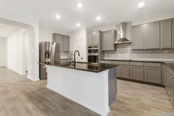 a kitchen with stainless steel appliances a sink stove refrigerator and cabinets