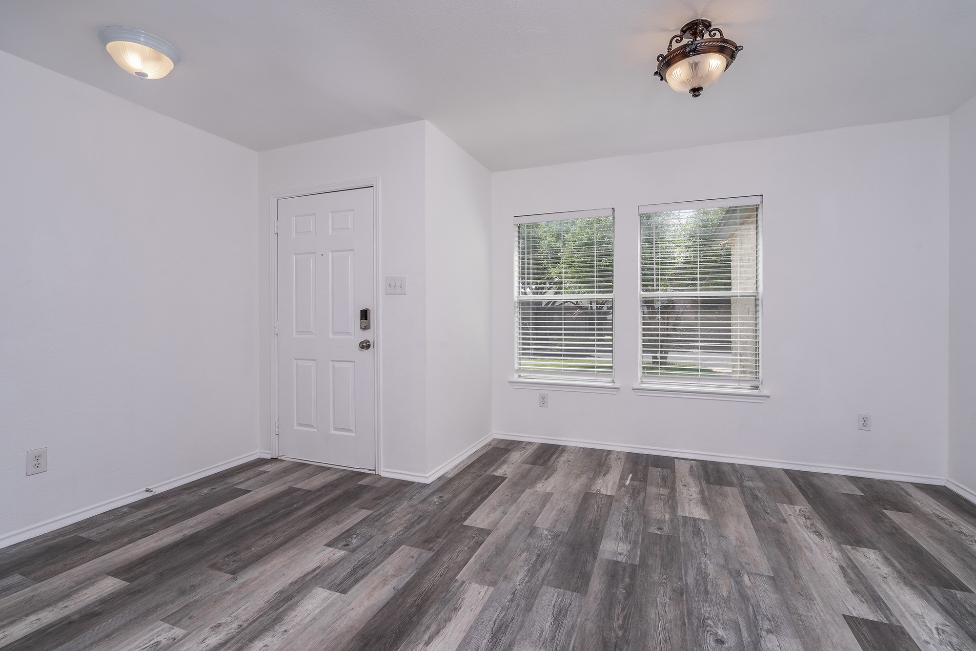 1305 Water Spaniel Way Round Rock, TX 78664 - Photo 5 of 27 wooden floor in an empty room with a window