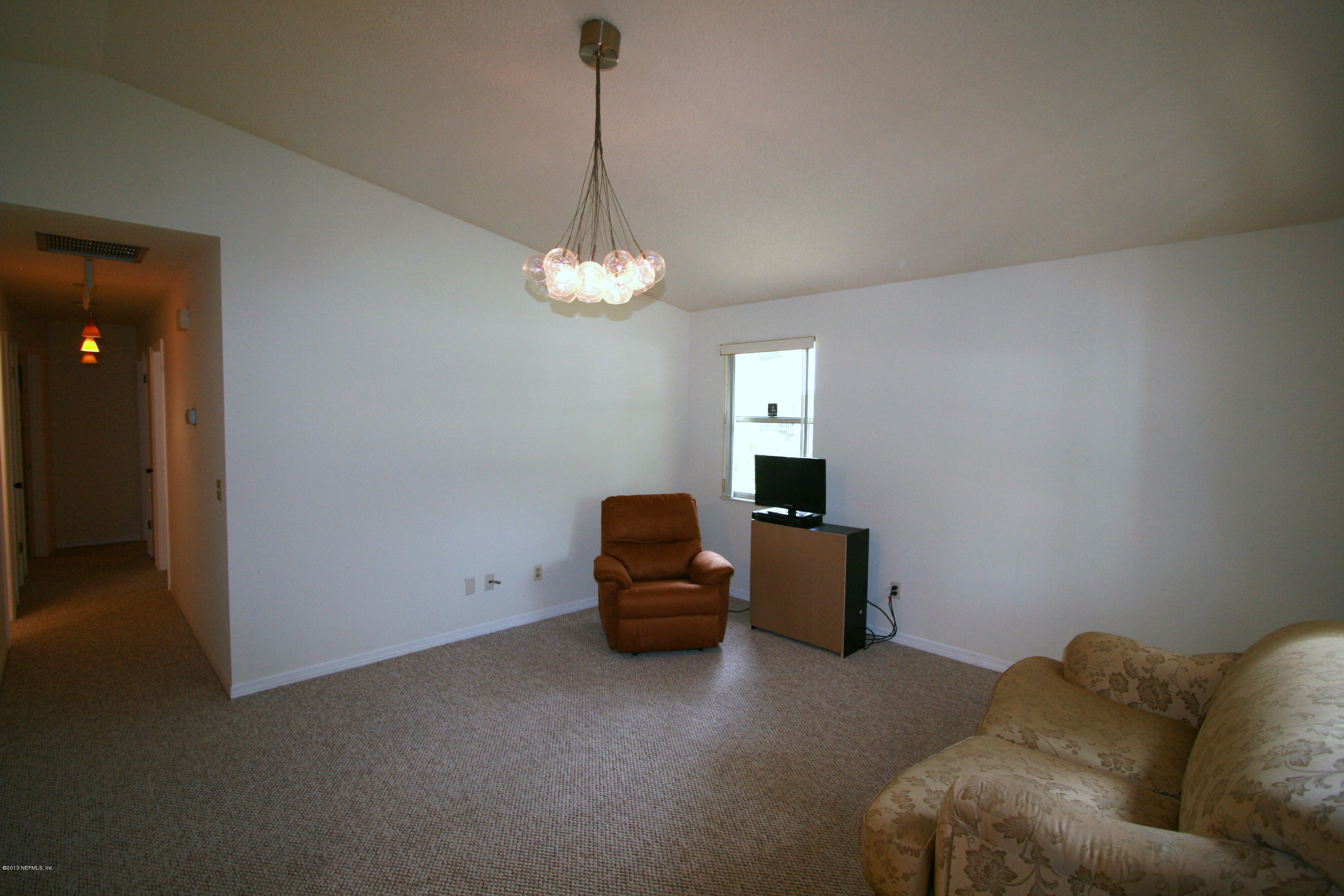 523 Gentian Road St. Augustine, FL 32086 - Photo 12 of 26 a bedroom with a bed and a chandelier