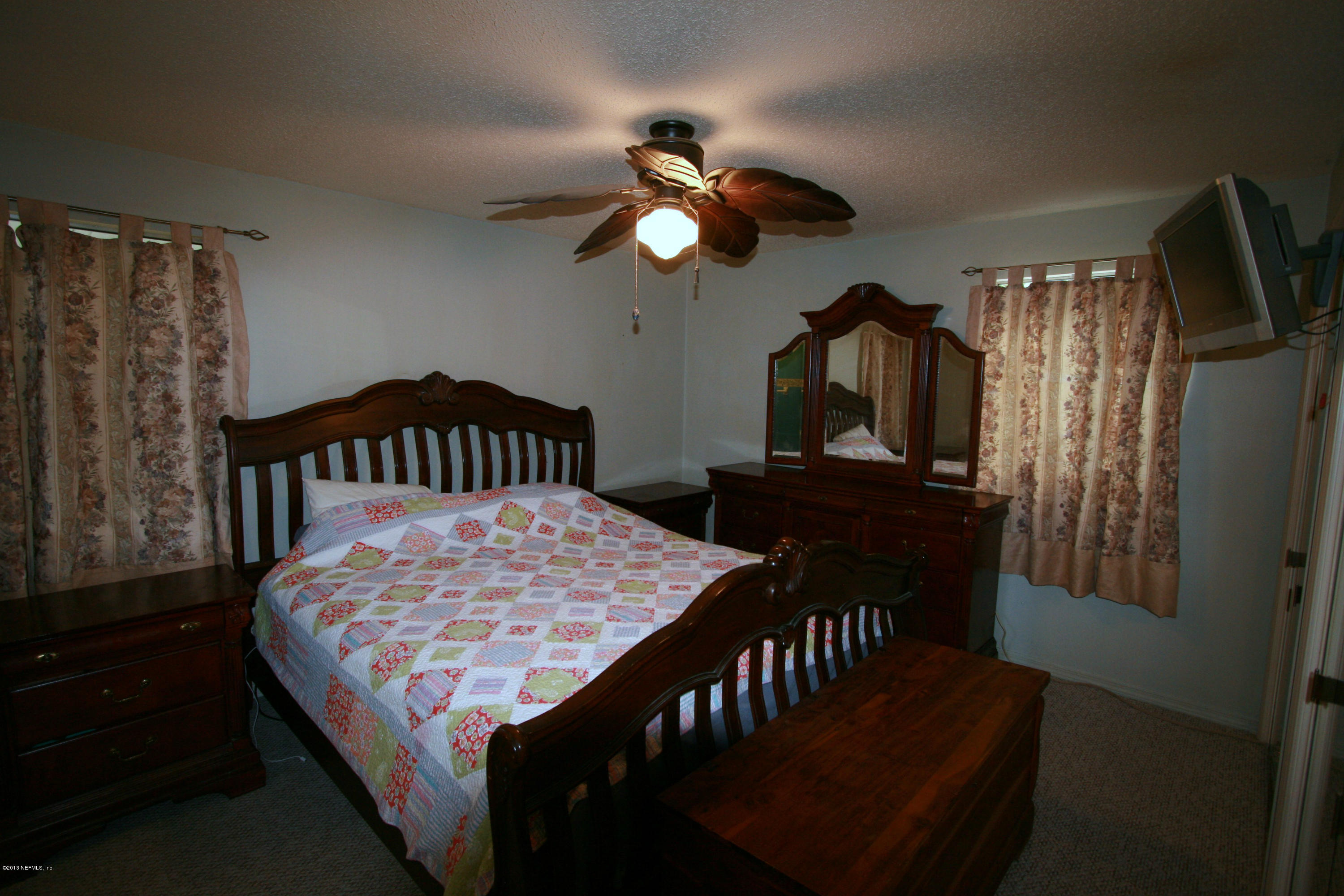 523 Gentian Road St. Augustine, FL 32086 - Photo 17 of 26 a bedroom with a bed a dresser and a chandelier