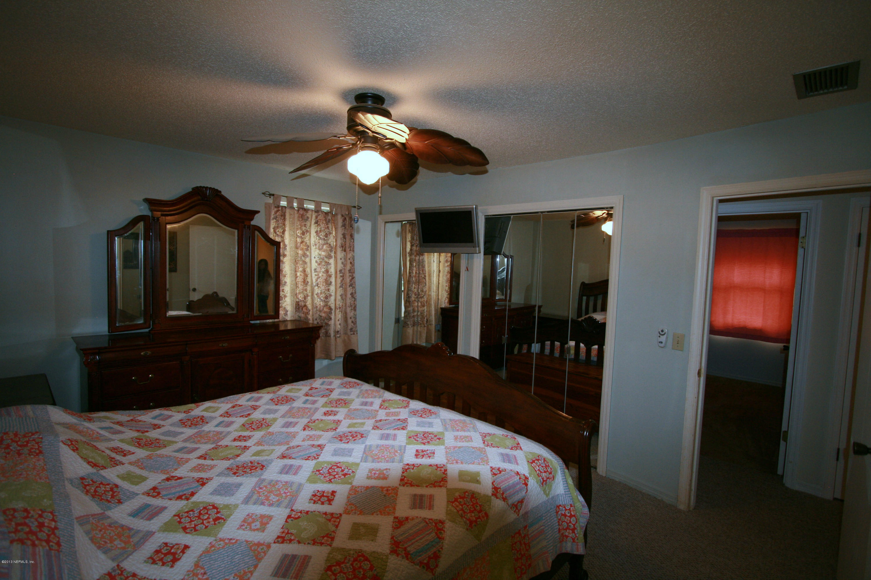 523 Gentian Road St. Augustine, FL 32086 - Photo 18 of 26 a bedroom with a bed and a large mirror