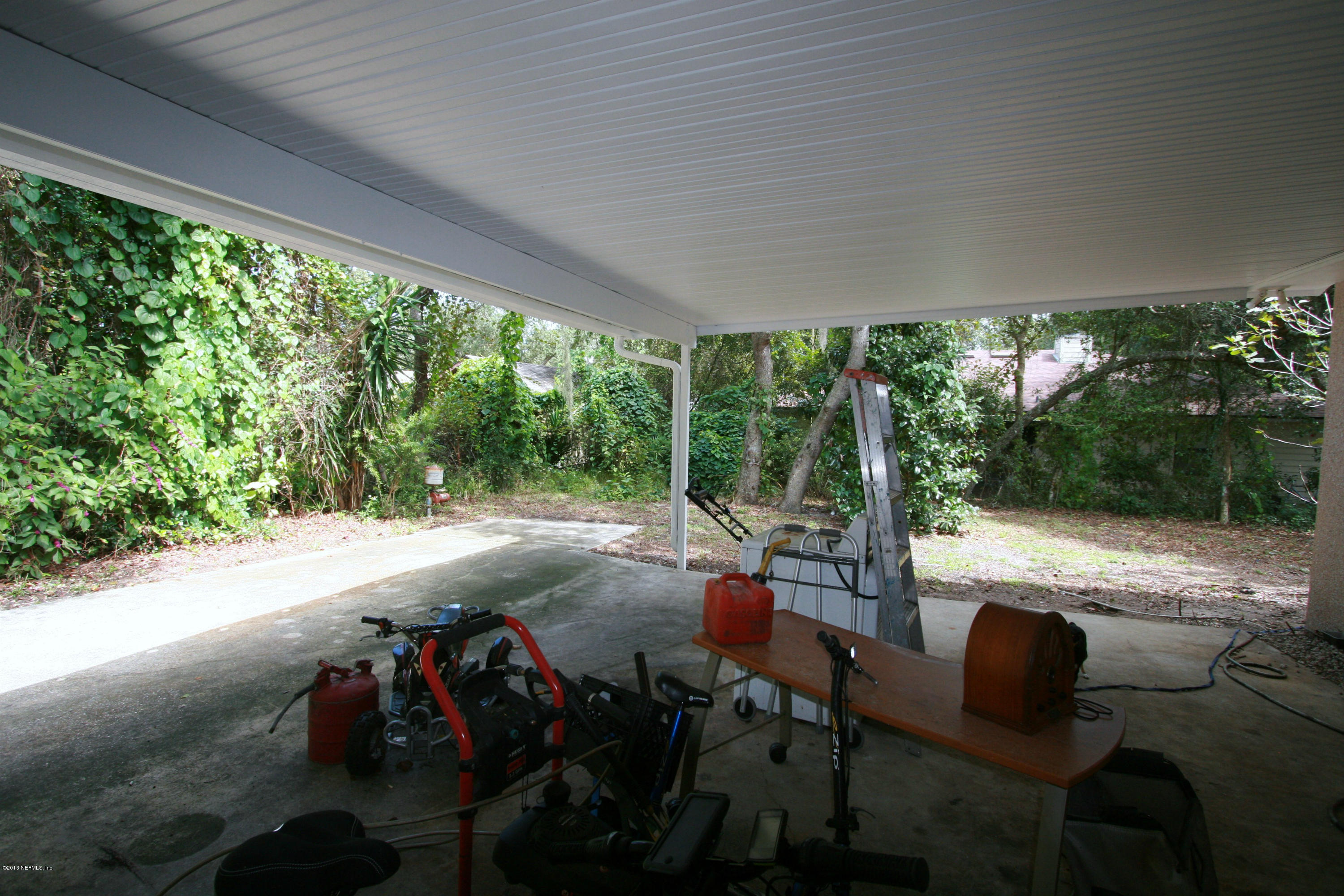 523 Gentian Road St. Augustine, FL 32086 - Photo 6 of 26 a view of a patio with lawn chairs next to a yard