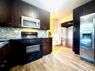 a kitchen with stainless steel appliances granite countertop a stove a sink and a microwave