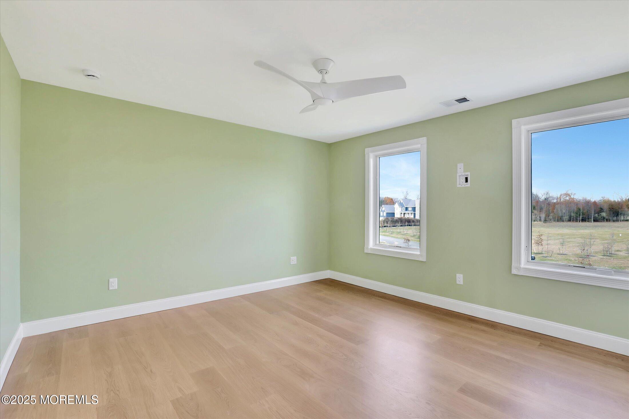 12 Cook Court Millstone Township, NJ 08535 - Photo 20 of 54 a view of an empty room with a window and wooden floor