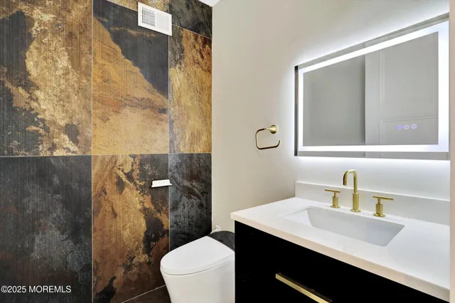 a bathroom with a sink vanity toilet and shower