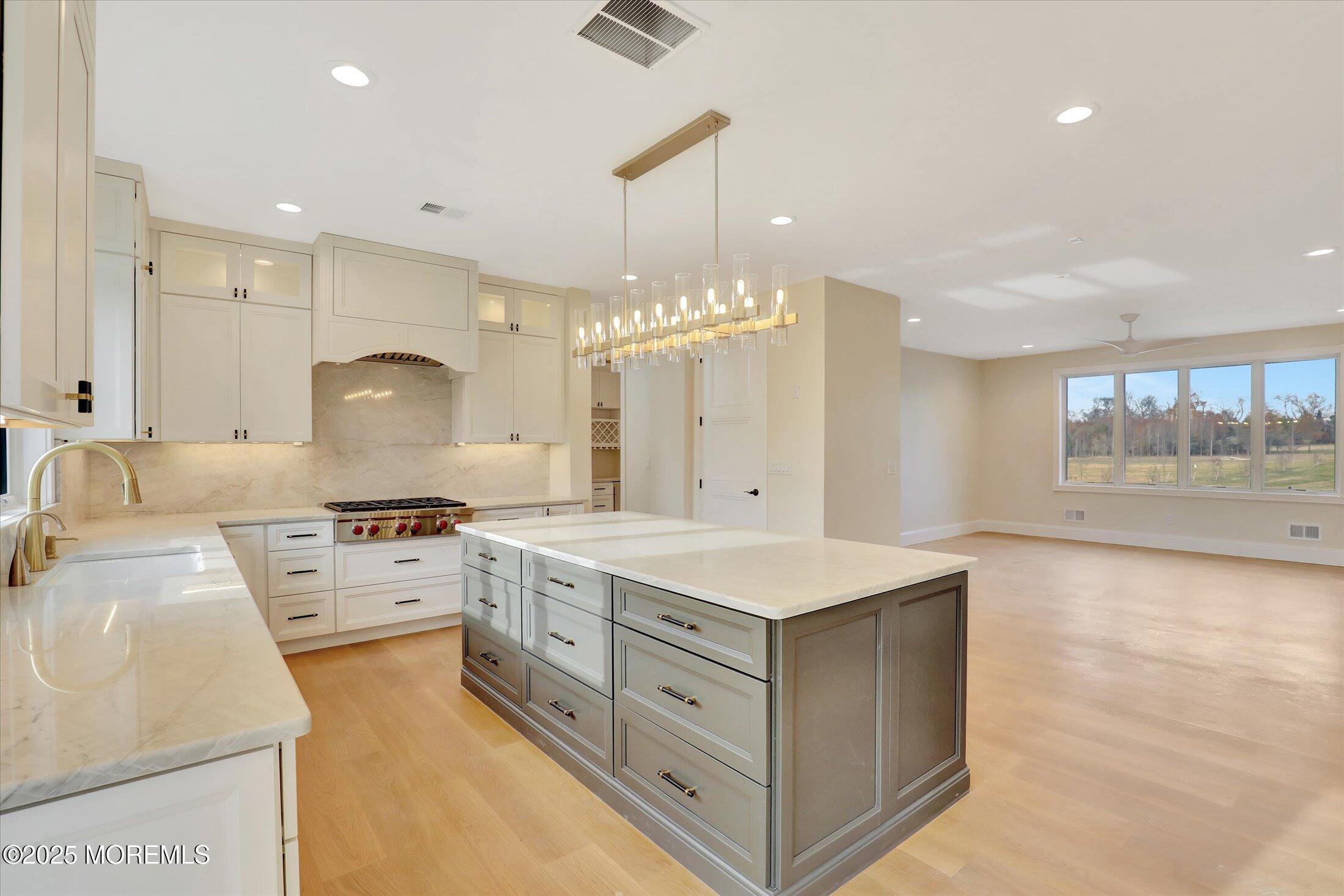 12 Cook Court Millstone Township, NJ 08535 - Photo 27 of 54 a large kitchen with kitchen island a stove a sink a center island and windows