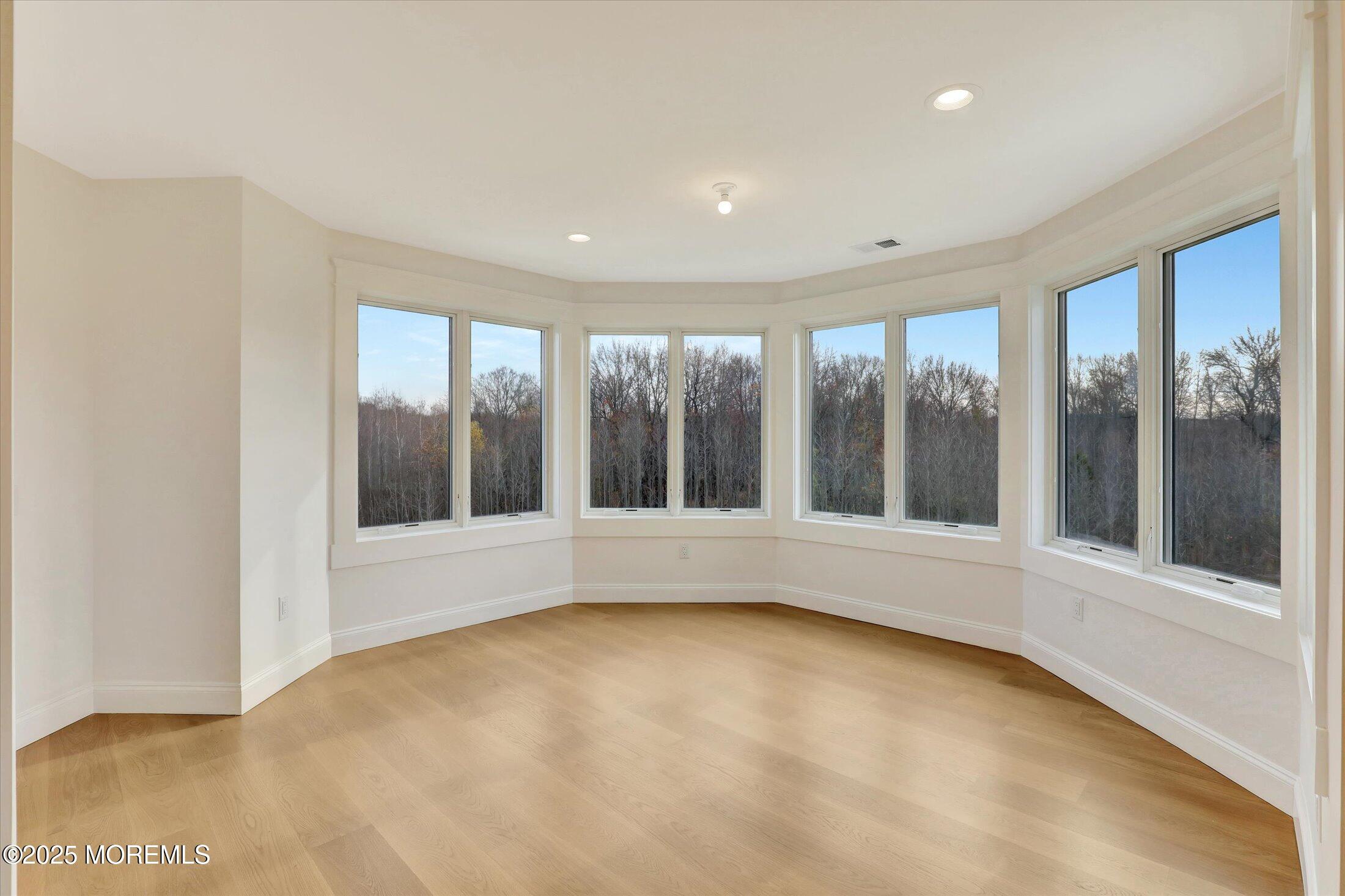 12 Cook Court Millstone Township, NJ 08535 - Photo 38 of 54 a view of an empty room with a window and hardwood floor