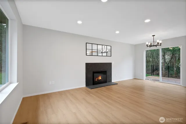 a view of empty room with wooden floor and fireplace