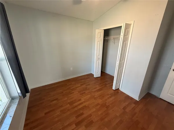 an empty room with wooden floor and entrance