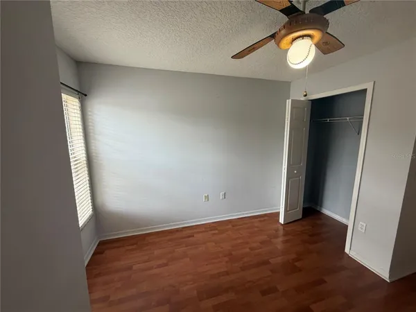 an empty room with closet and windows
