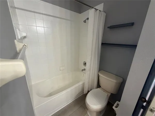 a white toilet sitting next to a bath tub
