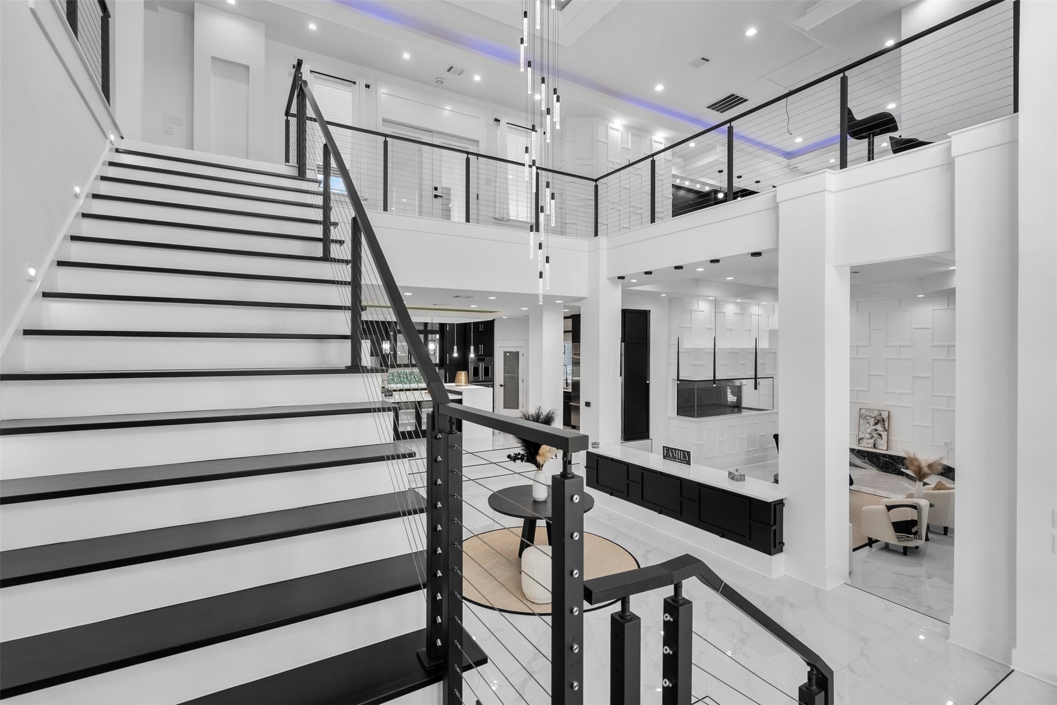 12 County Road 3558 Cleveland, TX 77327 - Photo 20 of 50 Elegant metal staircase leading to the second floor, highlighted by vaulted ceilings with LED trim lighting and stair rails accented with built-in LED lights for a modern, dramatic effect.