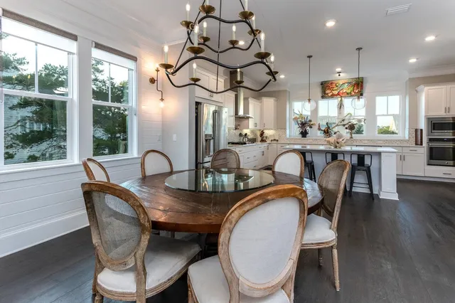 a dining room with furniture a chandelier and wooden floor