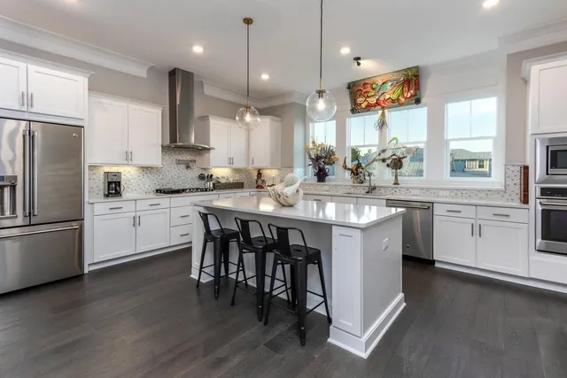 a kitchen with white cabinets appliances and a center island