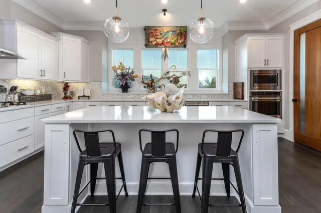 a kitchen with granite countertop a table chairs stove and cabinets