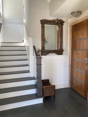a view of a livingroom with wooden floor and stairs