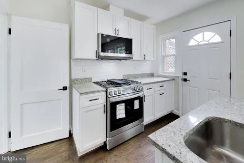 a kitchen with granite countertop a sink and a stove top oven