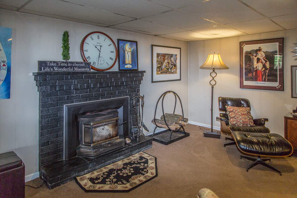 5720 Battlefield Road Harrisonburg, VA 22801 - Photo 25 of 41 a living room with furniture a clock and a fireplace