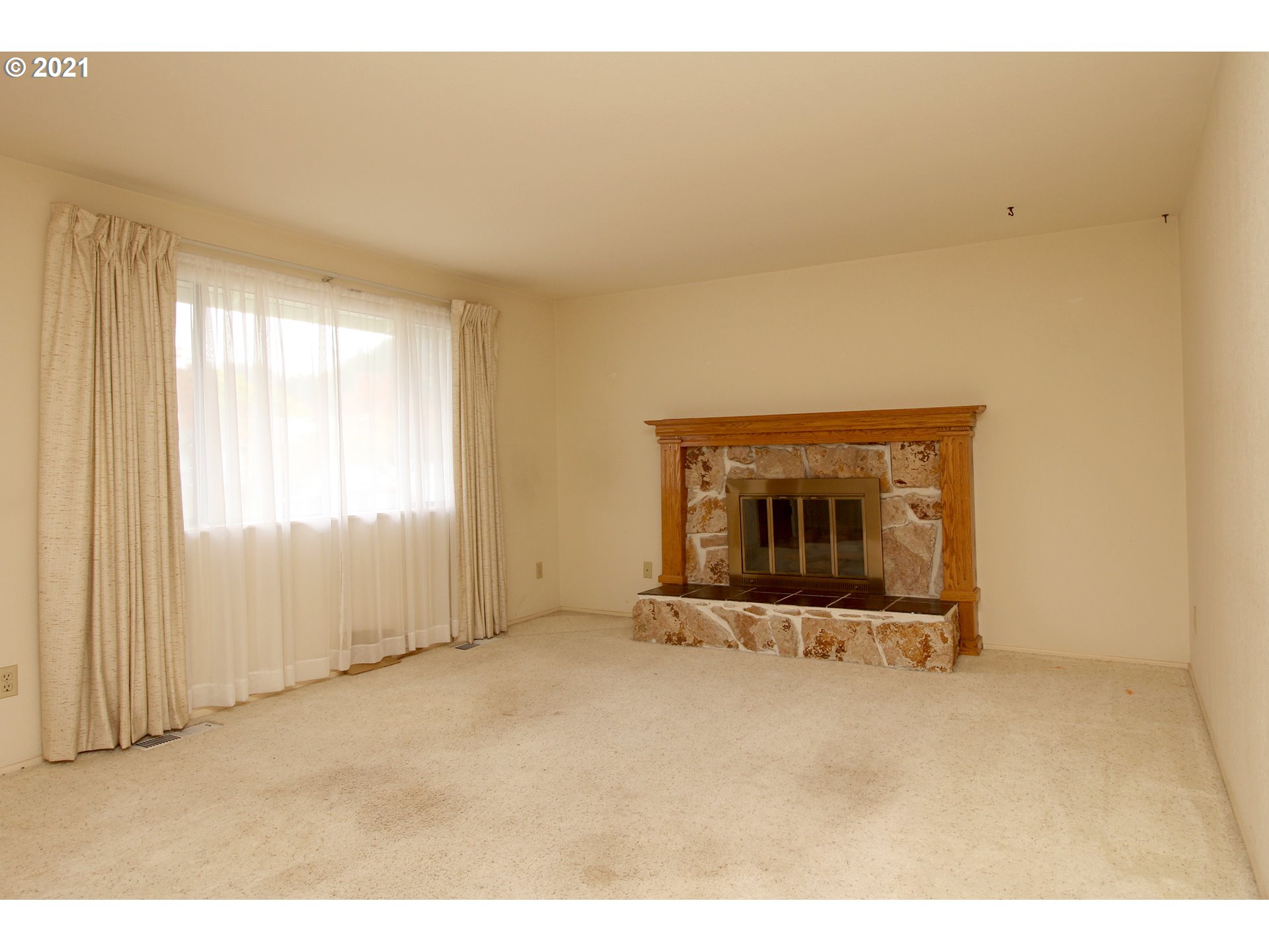 6988 B Street Springfield, OR 97478 - Photo 5 of 31 a view of an empty room with a fireplace and a window