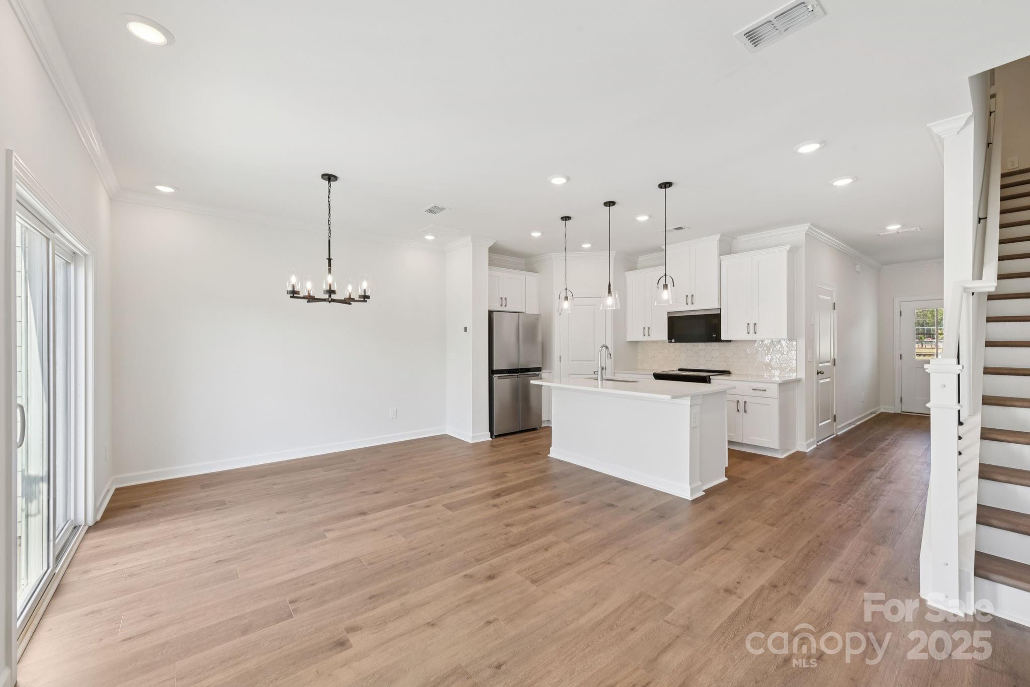 278 Tiger Lily Drive Fort Mill, SC 29708 - Photo 2 of 18 a view of kitchen with stainless steel appliances kitchen island granite countertop a refrigerator a stove and white cabinets with wooden floor