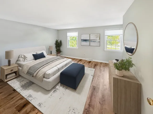 a bedroom with bed and a potted plant on table