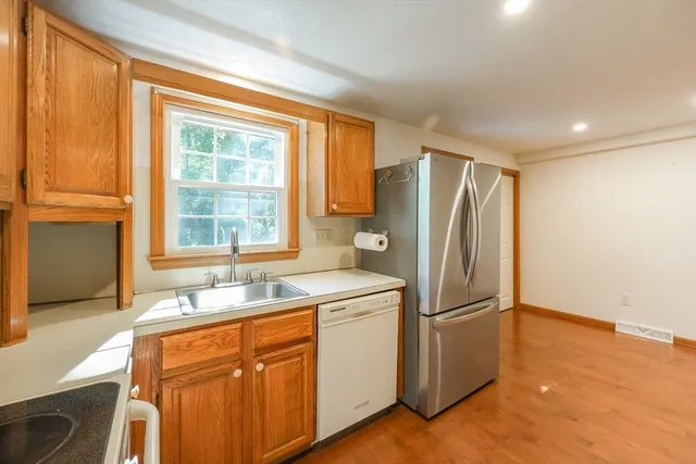 a kitchen with stainless steel appliances granite countertop a refrigerator and a sink