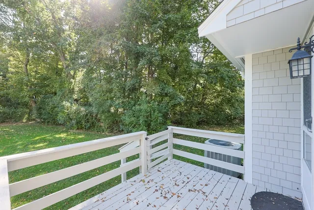 a view of a backyard with wooden fence and large trees