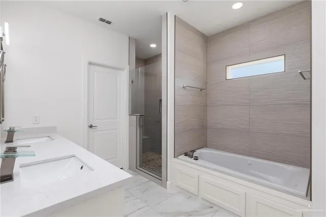 a bathroom with a tub a sink and a large mirror