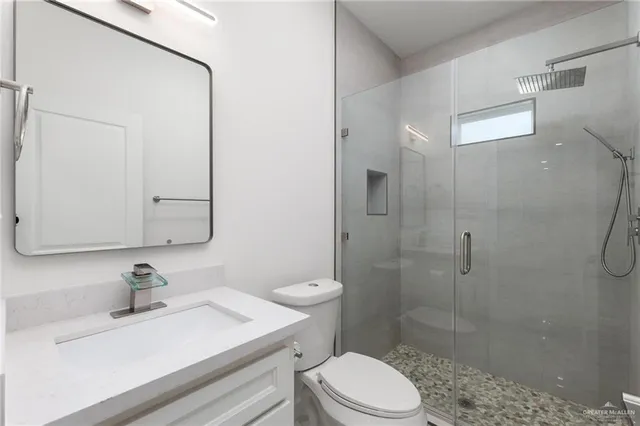 a bathroom with a sink a toilet and shower