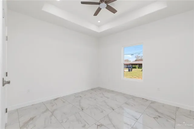 an empty room with a window and ceiling fan
