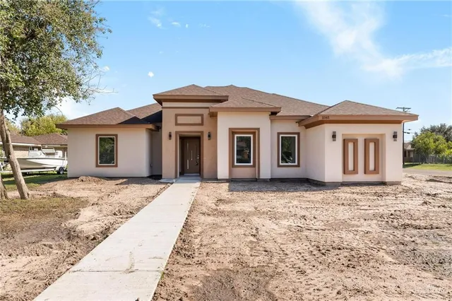 a front view of a house with a garden