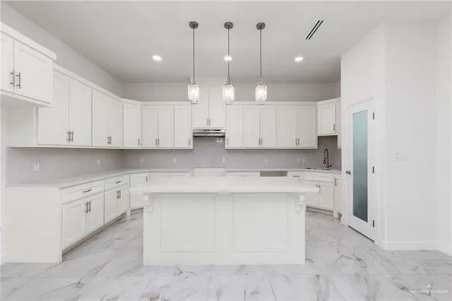 a large kitchen with cabinets and stainless steel appliances