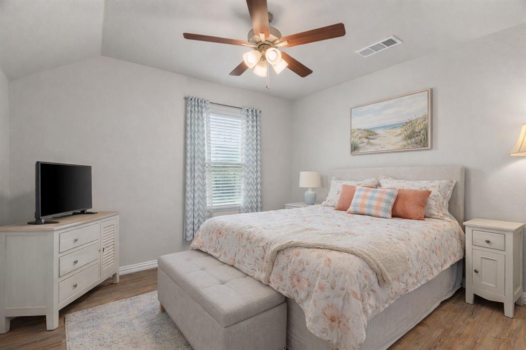 608 Porcupine Drive Springtown, TX 76082 - Photo 13 of 37 a bedroom with a large bed and a flat screen tv