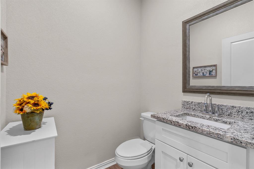 608 Porcupine Drive Springtown, TX 76082 - Photo 20 of 37 a bathroom with a granite countertop sink mirror vanity and toilet