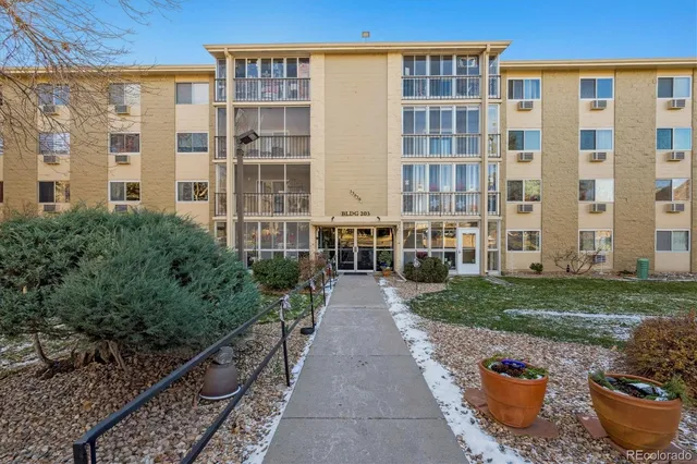 a front view of a house with a garden and a car parked