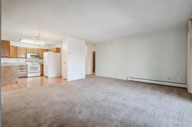 a view of an empty room with a kitchen