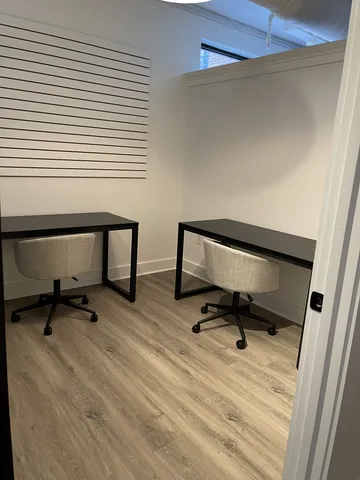 a view of a workspace with furniture and a window