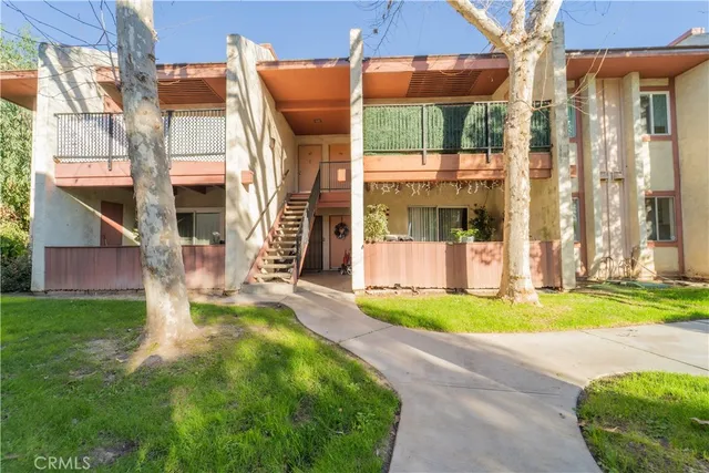 a view of a house with a yard and pathway