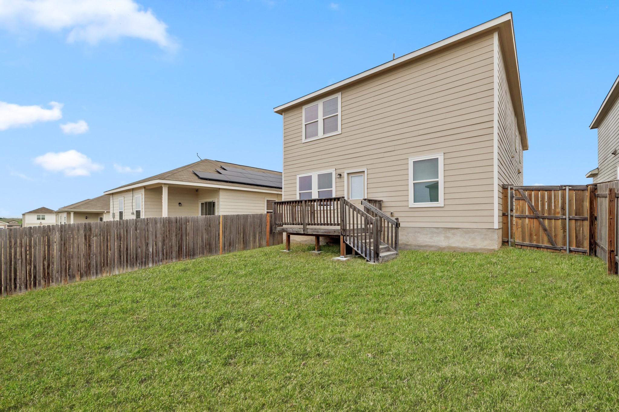 241 Night Riders Way Jarrell, TX 76537 - Photo 29 of 39 Back of property with a deck, a fenced backyard, and a gate