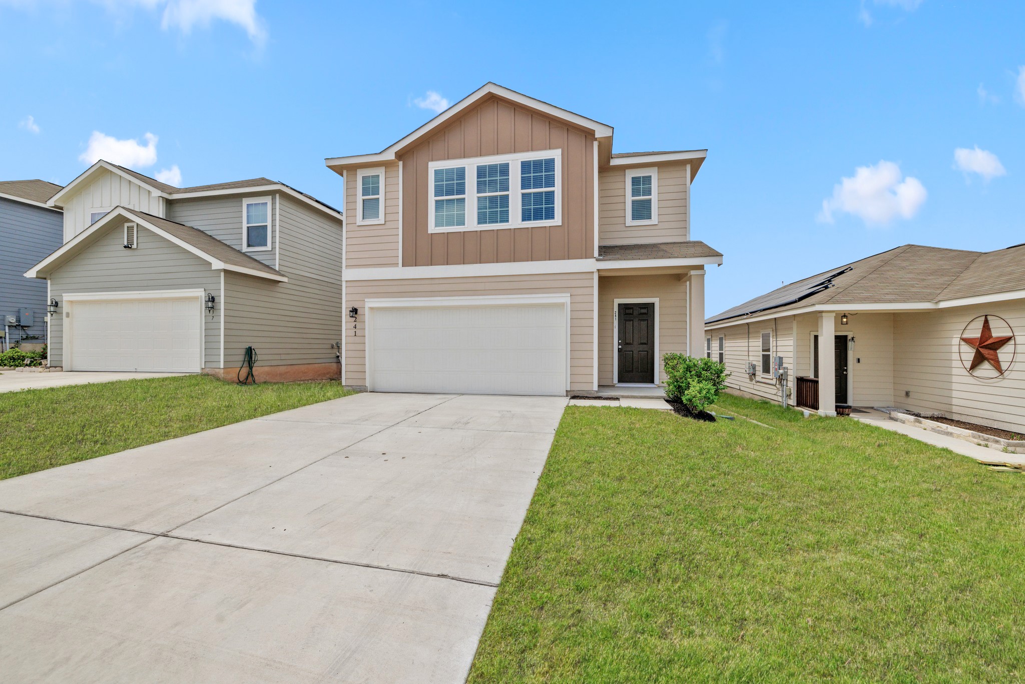 241 Night Riders Way Jarrell, TX 76537 - Photo 3 of 39 View of front of home with board and batten siding, driveway, an attached garage, and a front yard