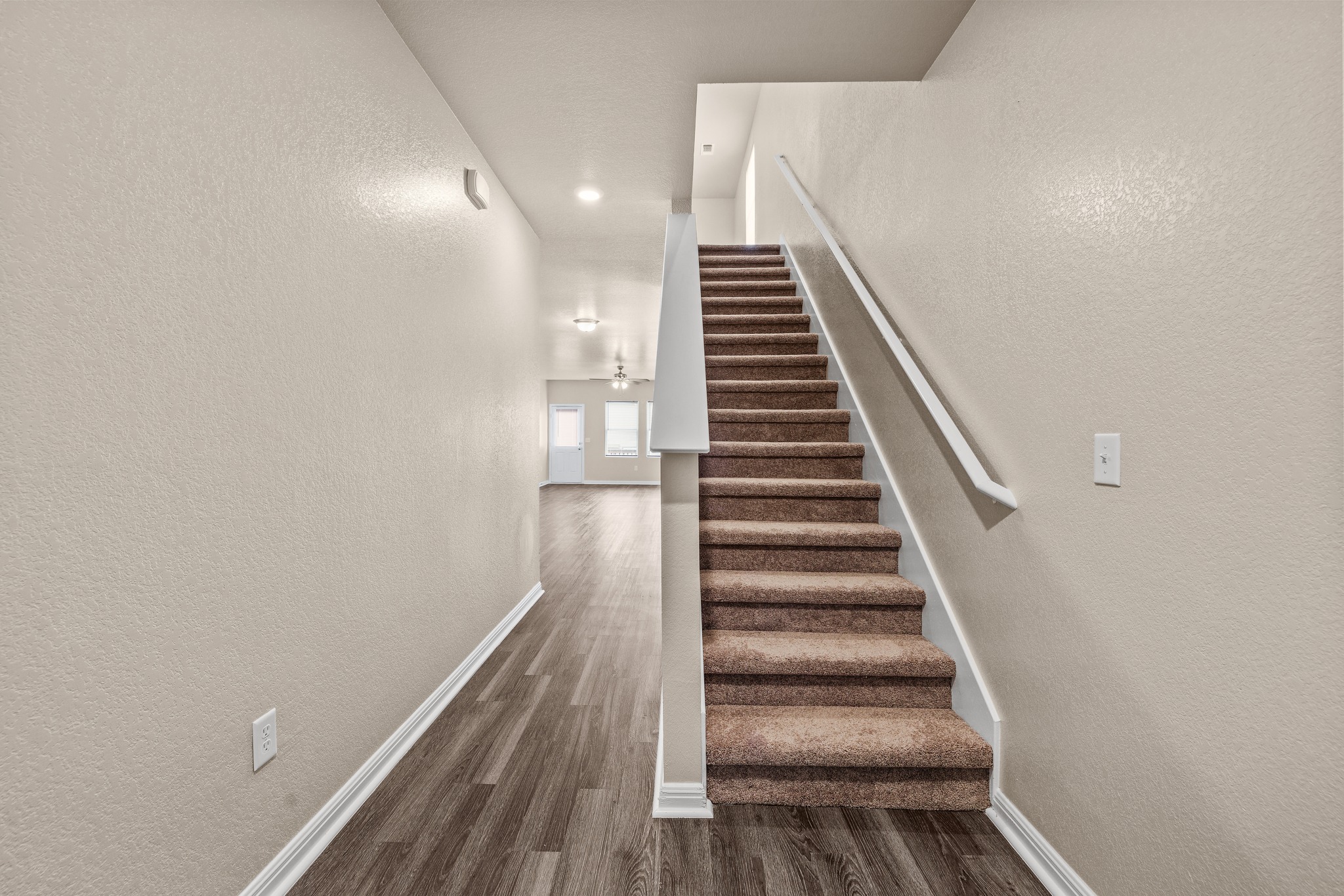 241 Night Riders Way Jarrell, TX 76537 - Photo 6 of 39 Staircase featuring a textured wall, wood finished floors, and recessed lighting