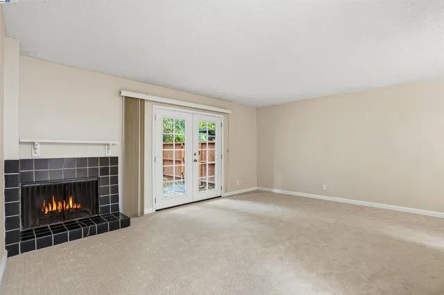 a view of an empty room with a fireplace and a fireplace