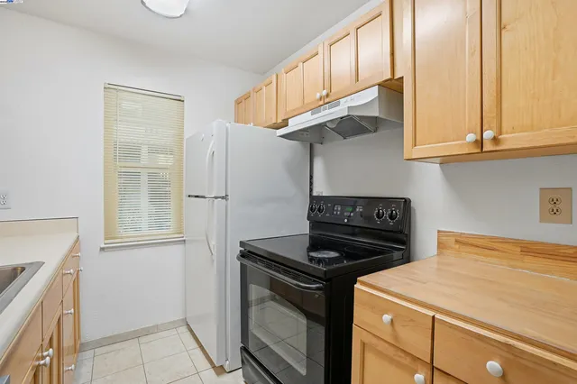 a kitchen with stainless steel appliances granite countertop a stove a refrigerator and a cabinets