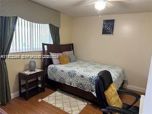 3571 Inverrary Drive, Unit 408 Lauderhill, FL 33319 - Photo 11 of 13 a bedroom with a bed and wooden floor