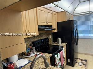3571 Inverrary Drive, Unit 408 Lauderhill, FL 33319 - Photo 6 of 13 a kitchen with a stove and a refrigerator