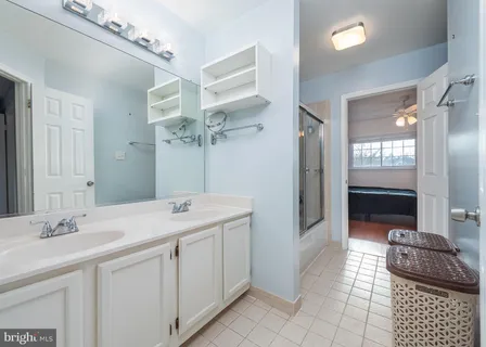a spacious bathroom with a double vanity sink a mirror and a shower