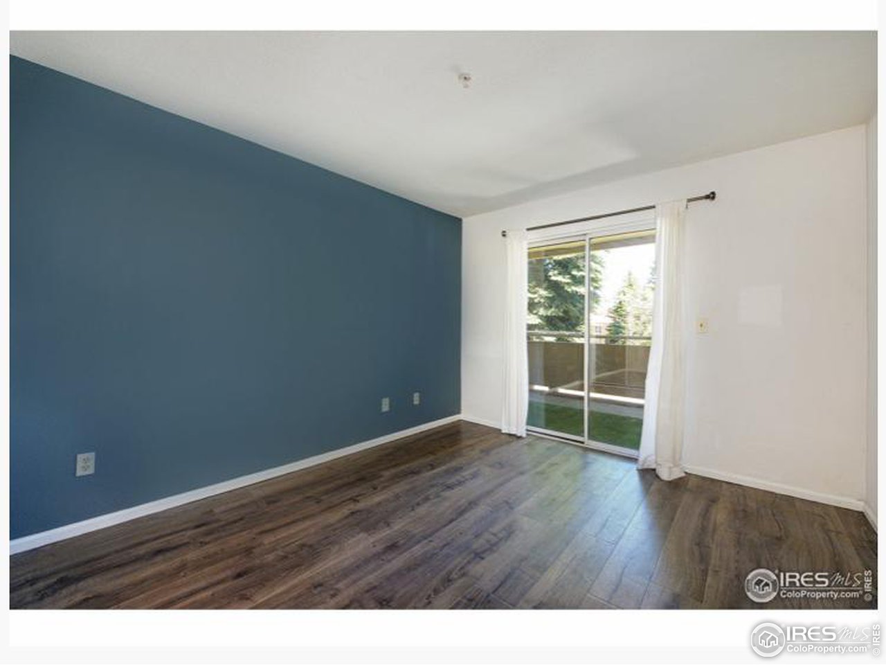 935 Broadway, Unit 106 Boulder, CO 80302 - Photo 15 of 34 a view of an empty room with wooden floor and a window