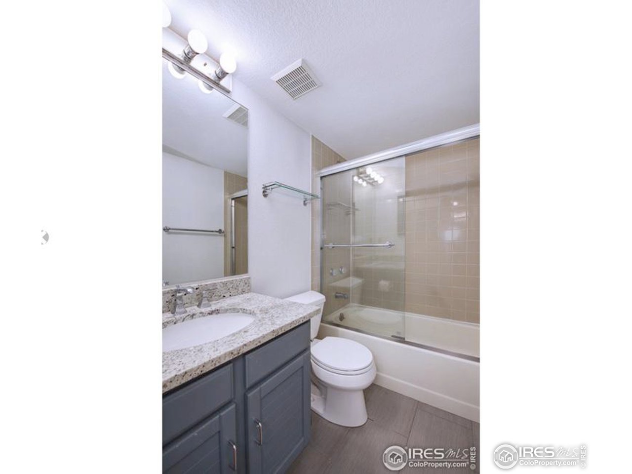 935 Broadway, Unit 106 Boulder, CO 80302 - Photo 16 of 34 a bathroom with a granite countertop sink toilet mirror and shower